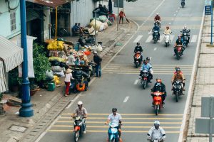 Foreign tourists riding motorbikes through Vietnam city traffic in 2026